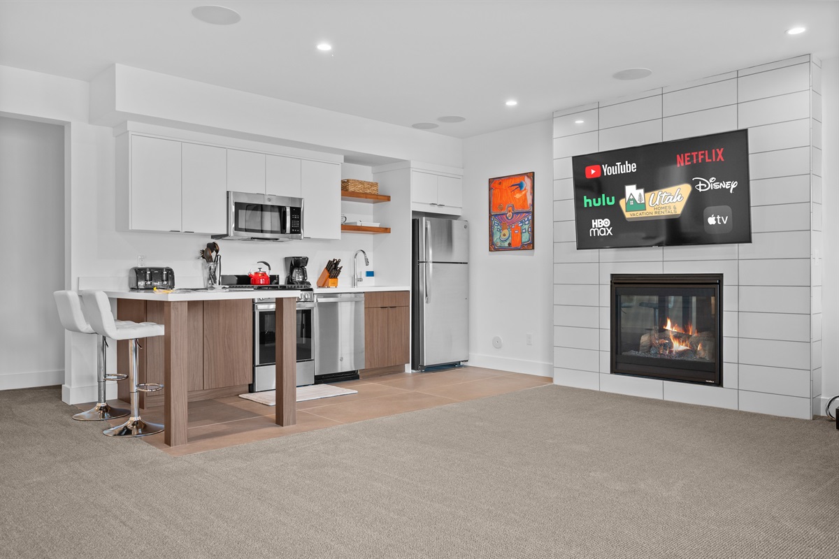 Fully equipped second kitchen and cozy living area with Smart TV and electric fireplace.