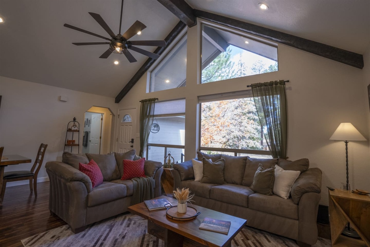 Open living space with tall windows, natural light, and a cozy setup for gathering after a day out.