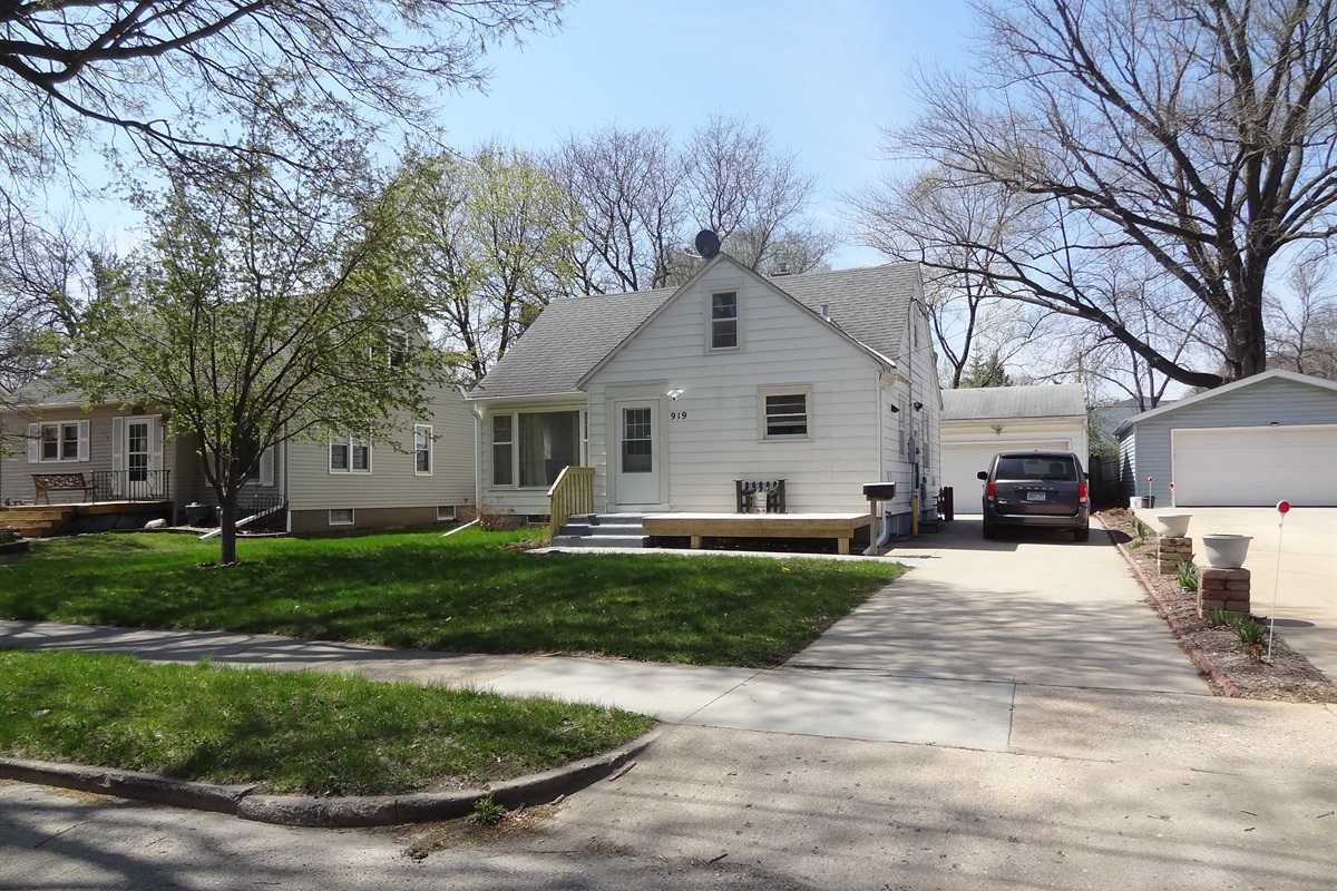 Deck on front of house and long driveway for parking
