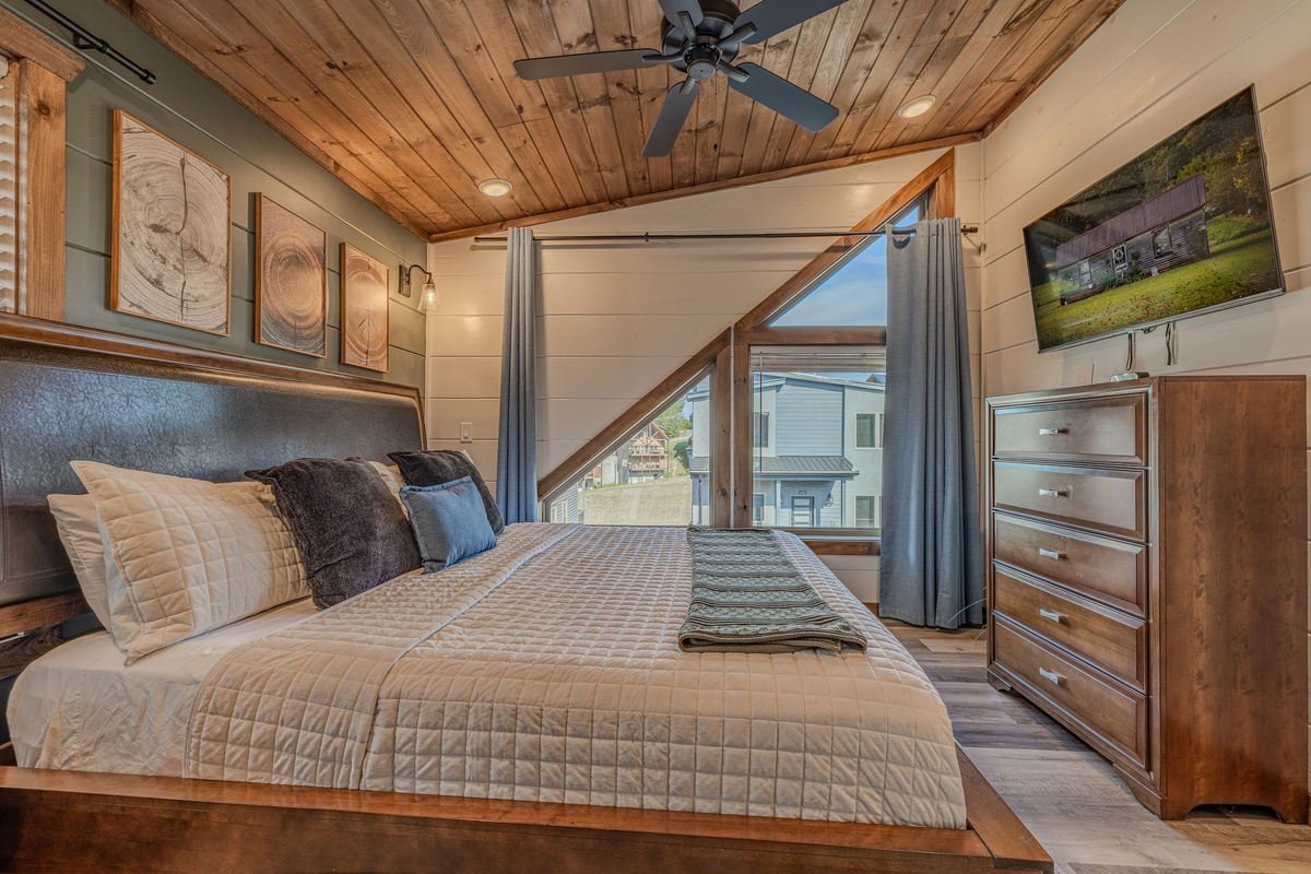 Upstairs King bedroom with an airy layout and vaulted wood ceiling.