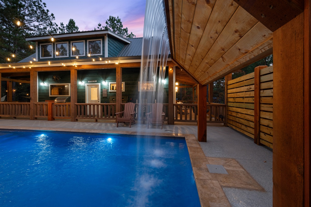 As the sun goes down, this view of the pool and patio shows how cozy the whole outdoor setup becomes at dusk.