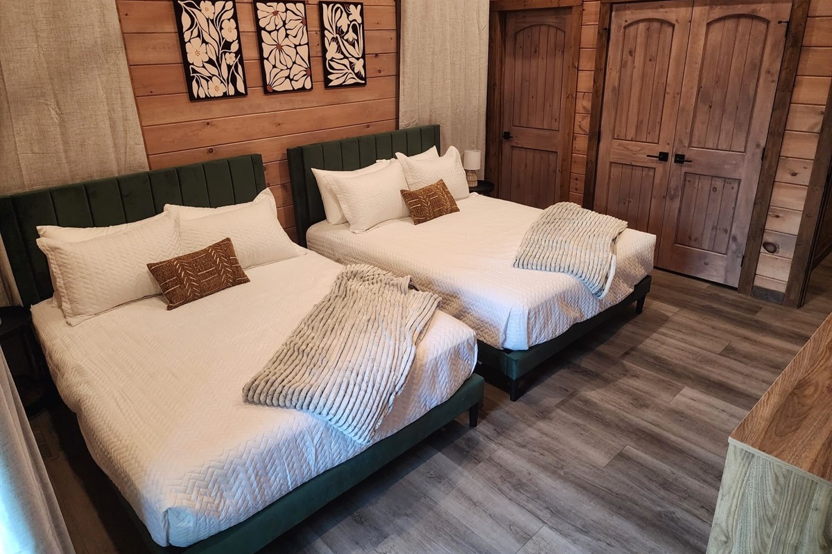Bedroom with two queen beds, modern art, and plush linens