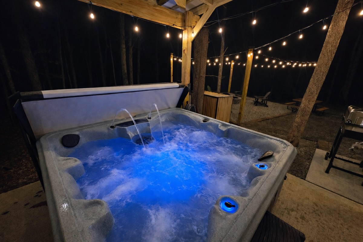 Sink into the glowing hot tub beneath twinkling string lights and the quiet forest night—an intimate, spa-like experience made for couples, honeymooners, and peaceful escapes