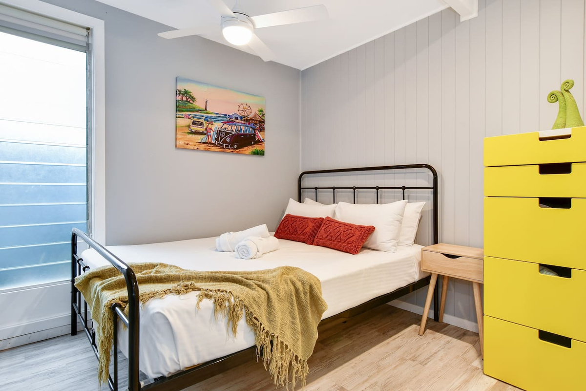 Natural light keeps this lower-level bedroom at Aaron's Beachside Boat House bright while maintaining a simple, private sleeping space.