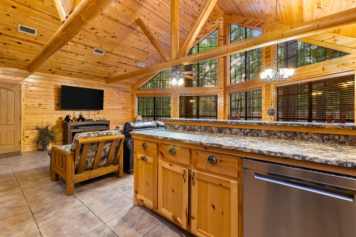 Open kitchen flows into living area with forest views all around
