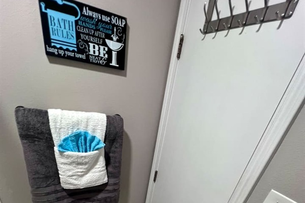Bathroom detail with fresh towels, wall hooks, and a few simple guest touches.

