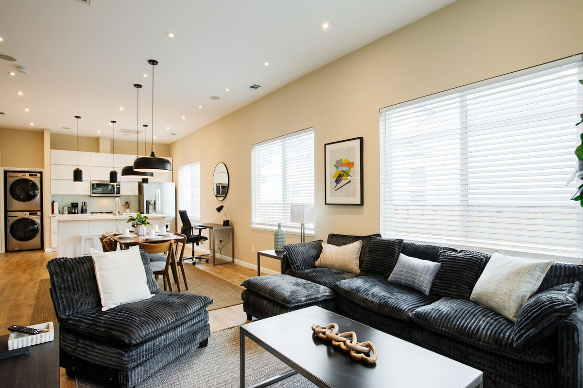 The Living Room is equipped with a sectional sofa, a 3-seater sofa,  an armchair, and a 65-inch flat screen smart TV