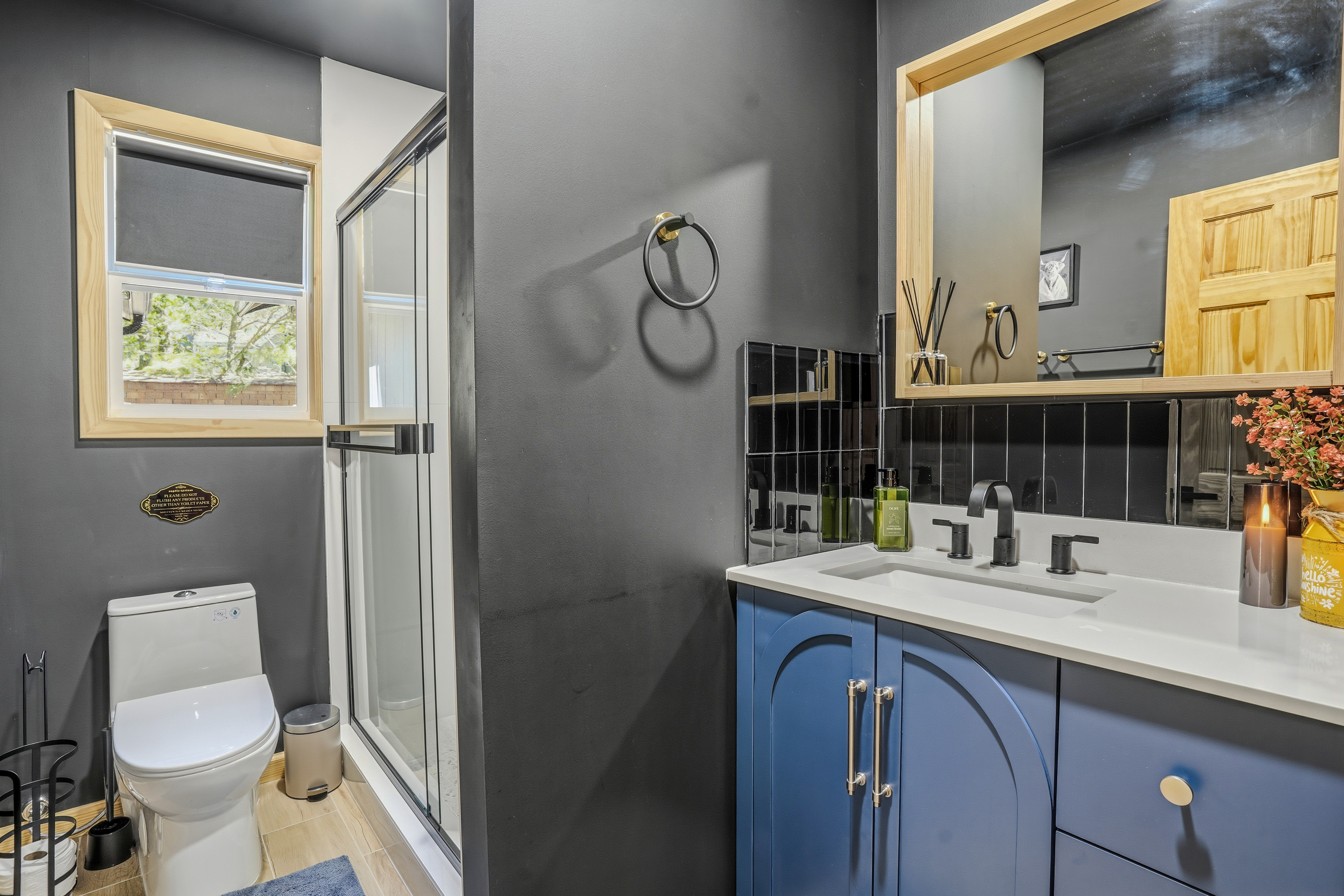Second bathroom with blue-gray cabinetry, white countertop, and tub/shower combo