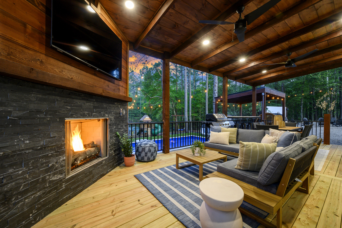 This is where everyone gathers. Settle in by the outdoor fireplace while staying connected to the pool, or grab a seat at the bar top overlooking the pool, playset, pond & pines beyond.