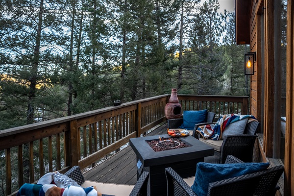 🔥🌲 Deck hangout goals—gather around the fire table with cozy seating, blankets, and pine-tree views for the ultimate mountain-night vibe ✨🥂