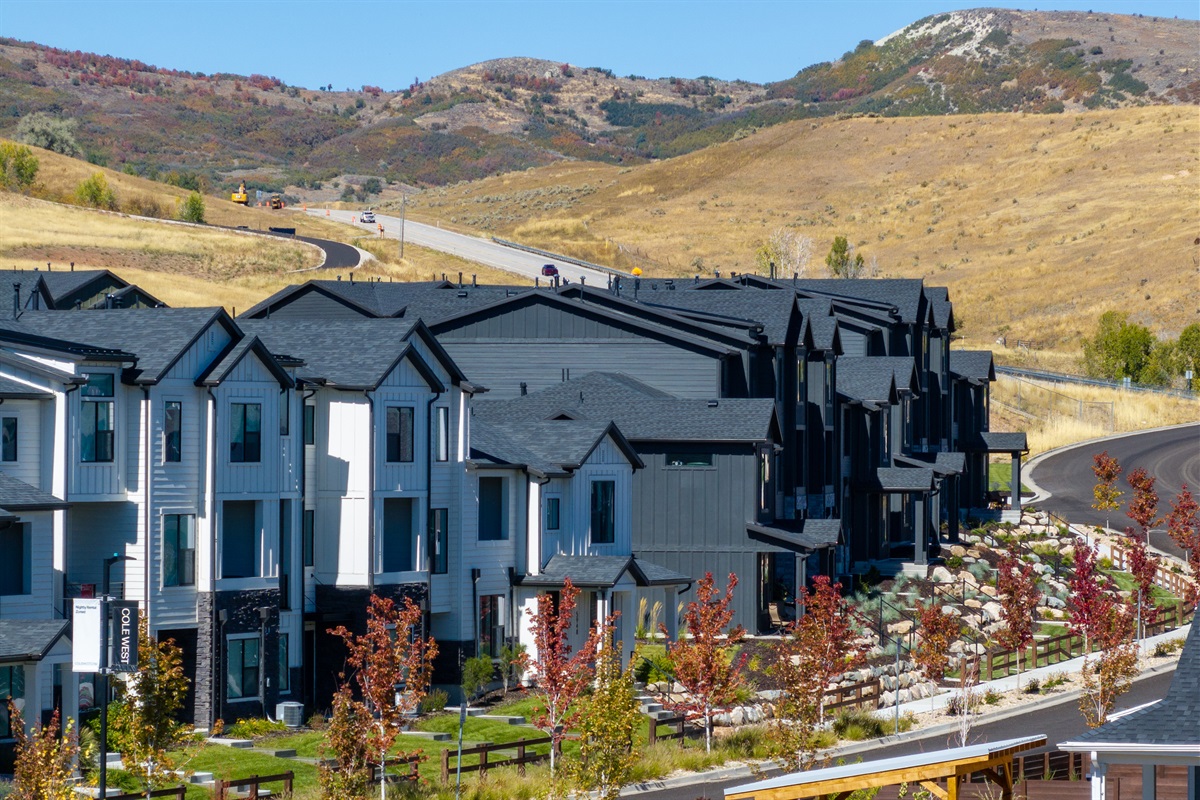 Scenic community setting with rolling hills and mountain surroundings.