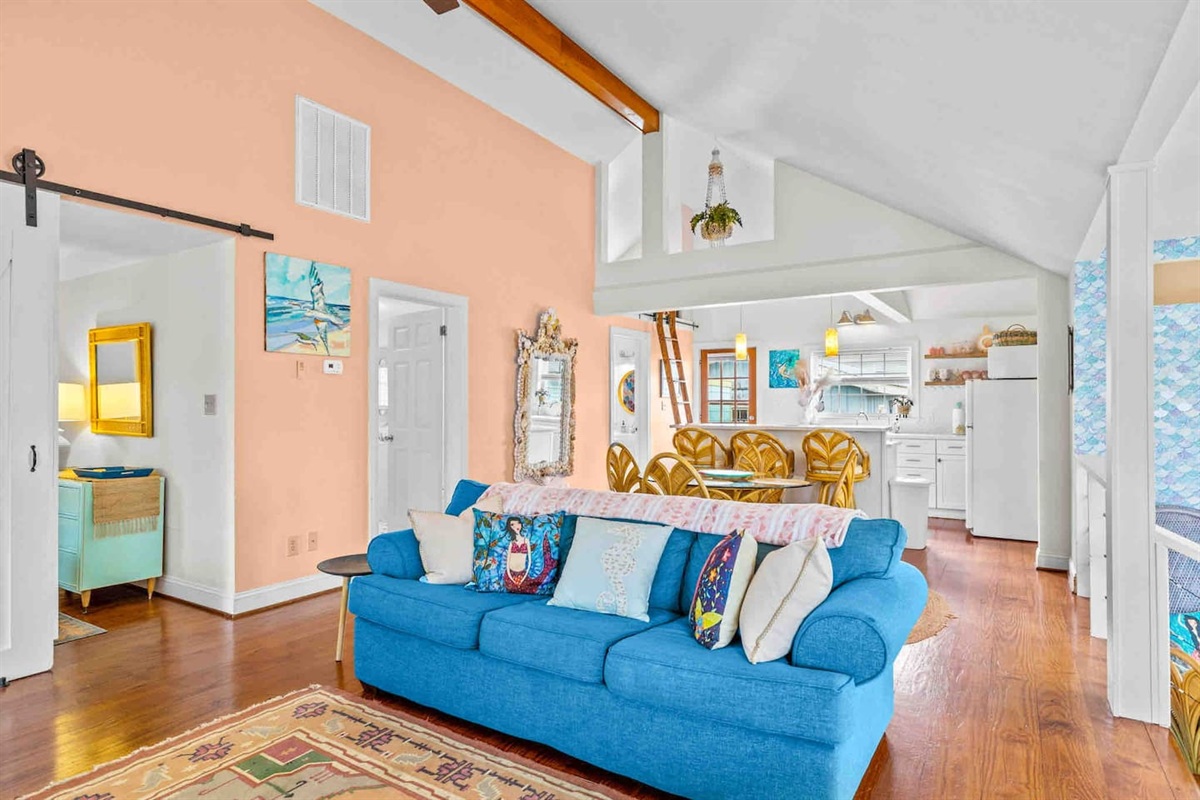The twin bedroom is to the left of the living room through the barn doors while the queen bedroom is to the right just off the kitchen behind the mermaid scales!
