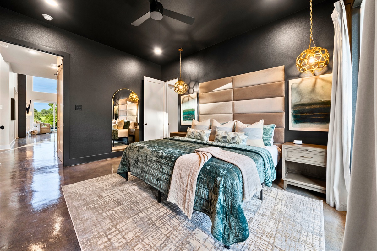 Modern pendant lights hang gracefully on either side of the bed, casting a warm, ambient glow that enhances the room's cozy feel.