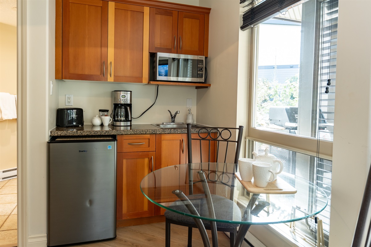 Modern and spacious kitchenette area including coffee bar. Enjoy your coffee on glass table or covered patio. Tons of room and open concept. Weber BBQ on covered patio as well!