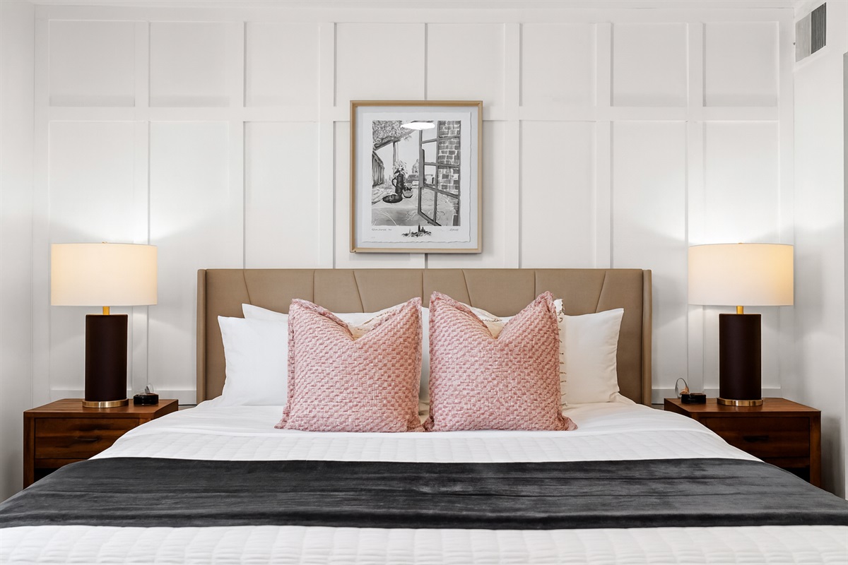 Relax in a spacious bedroom featuring a king-size bed, cozy pillows, warm lighting, and blackout curtains for a restful night’s sleep.