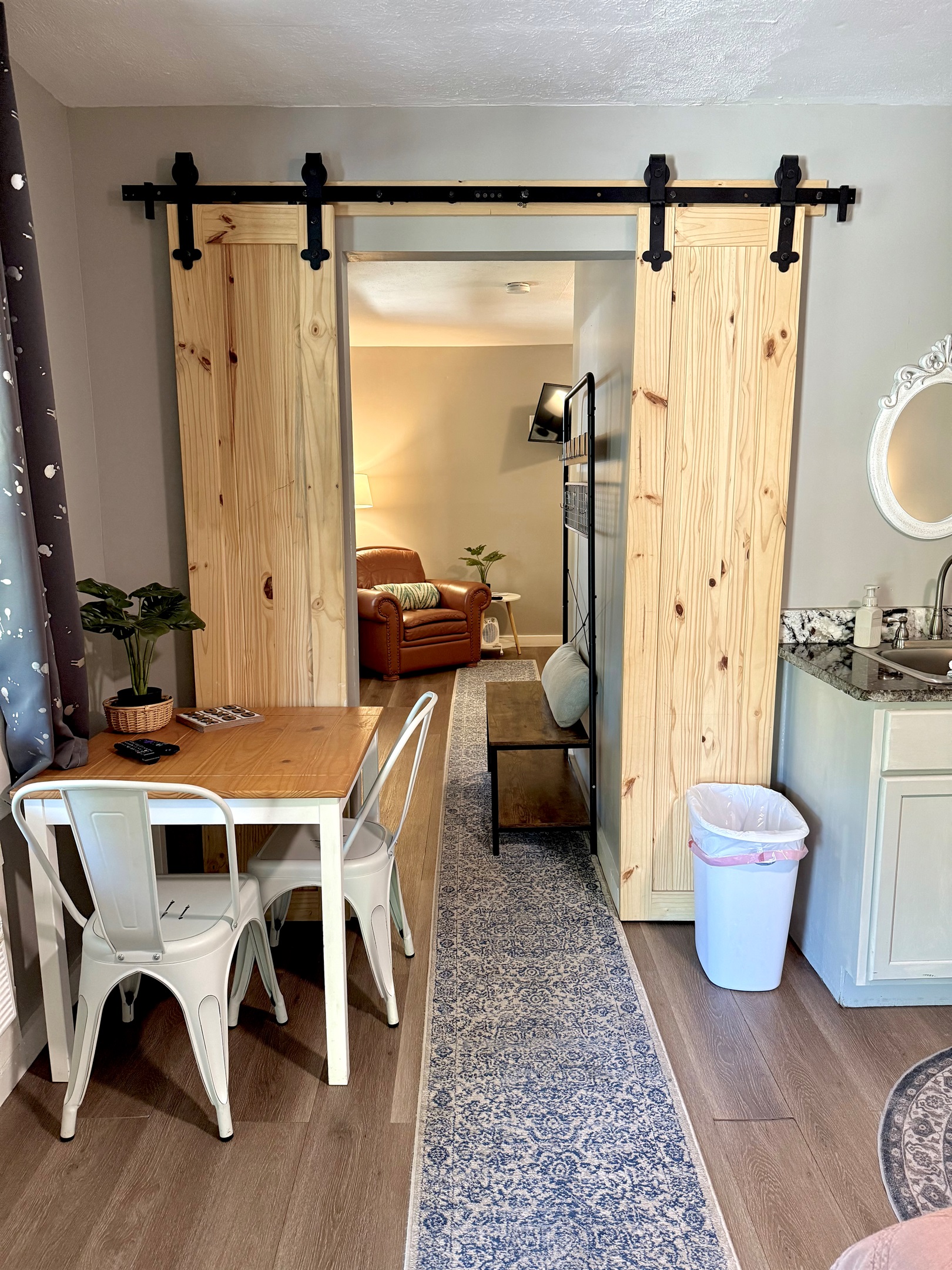 Barn doors to close off second bedroom for privacy. Small seating area in the room. 