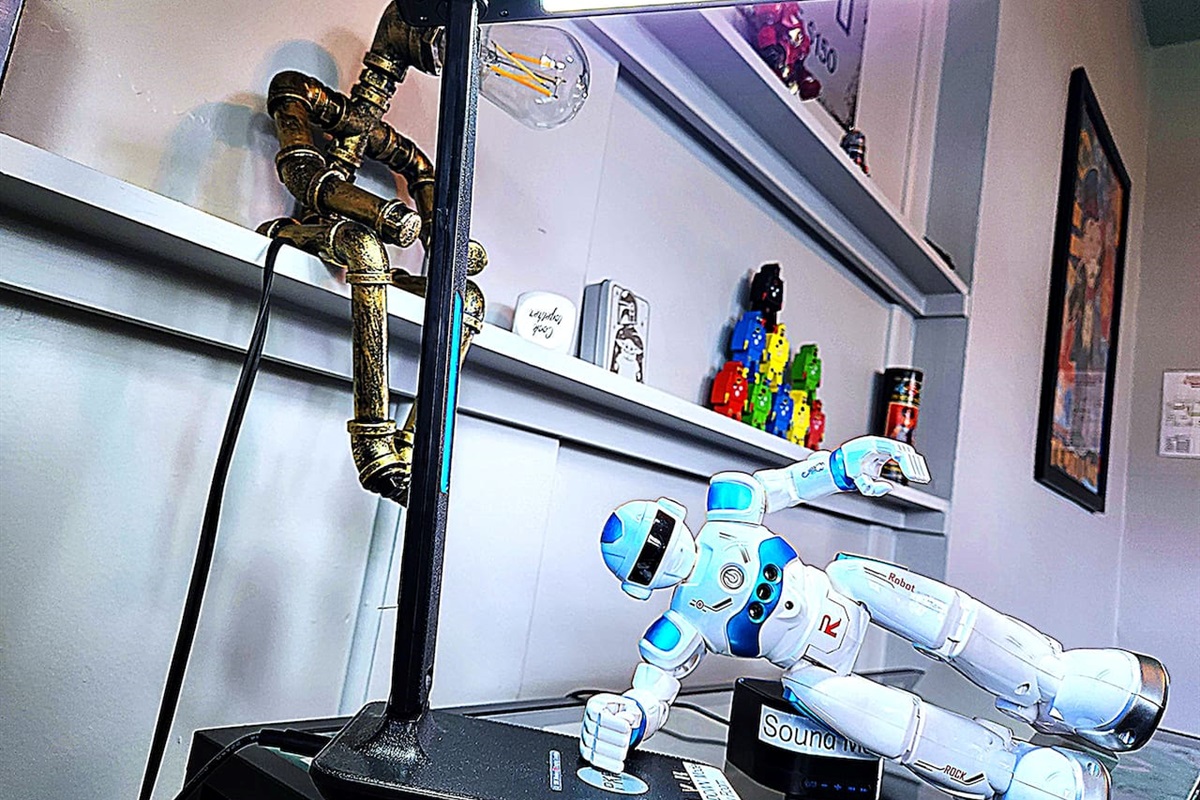 Howie SHOG demonstrates cell charging station and light at desk. 