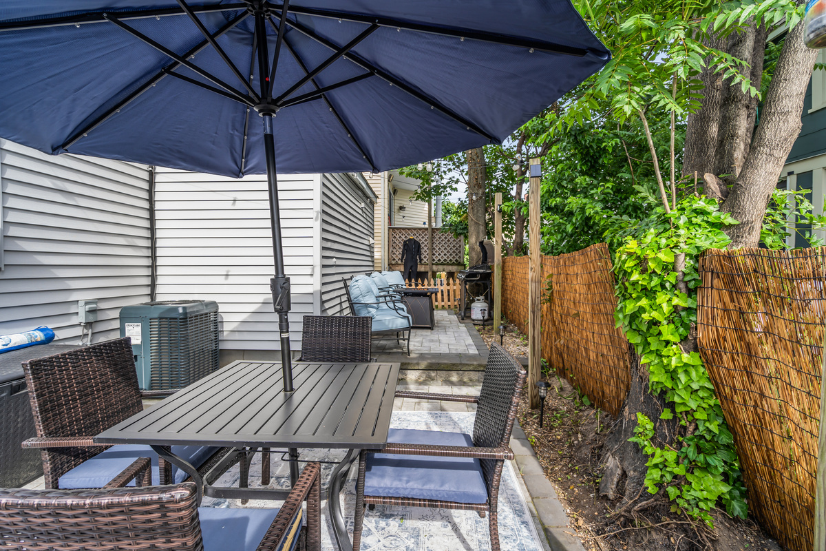 Settle in for breakfast, lunch or dinner outside during your stay under the navy umbrella, privacy fence around you and vines climbing the patio. This is where the long, slow shore days happen.