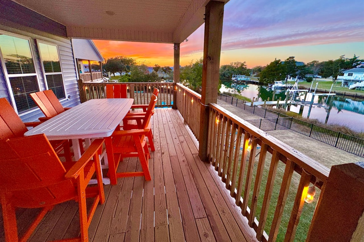 Private backyard dock with boat lift and fillet table, fenced-in backyard, fire pit with Adirondack chairs, hammocks, propane grill, picnic table, outdoor shower, expansive waterfront back deck with table and seating, neighborhood boat ramp and dock