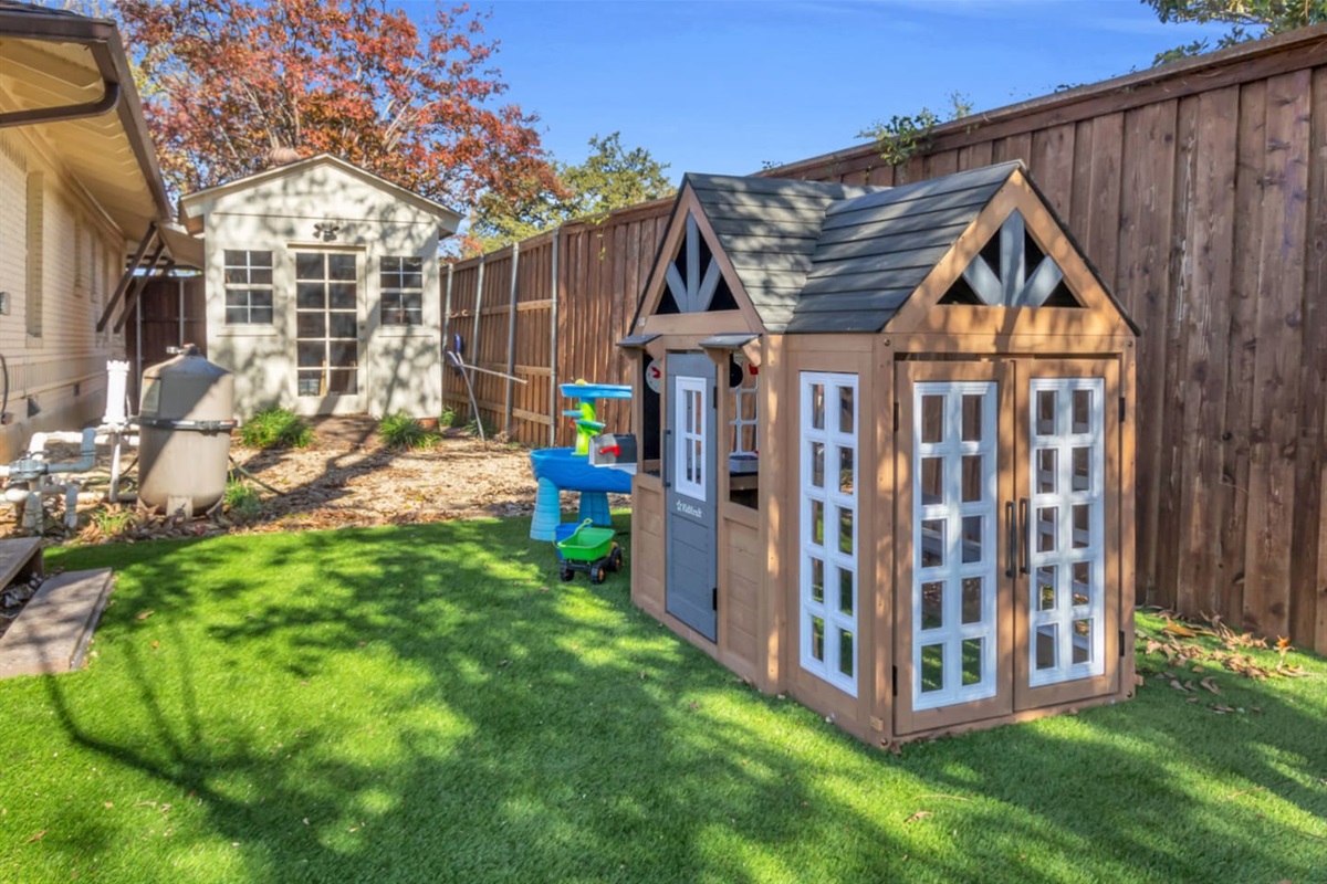 A bright, open backyard play zone with artificial turf for soft landings and endless fun—ideal for families looking for a kid-friendly stay.