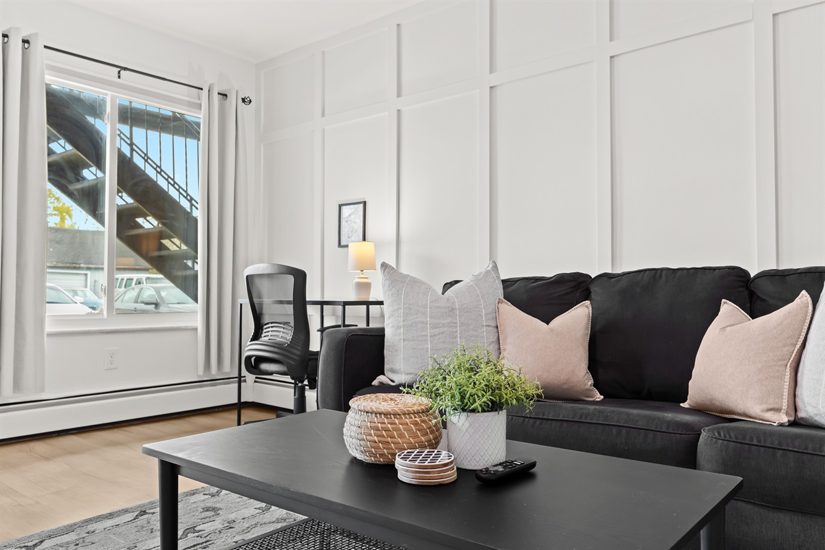 Relax in style or catch up on work in this bright, cozy living space with a dedicated desk area.