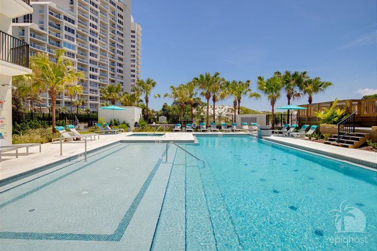 Pool deck with lounge seating and palm trees