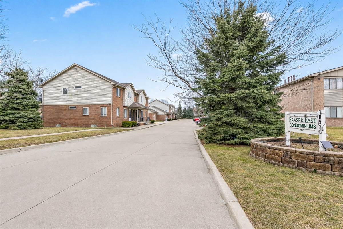 Quiet, tree-lined condo community with well-kept buildings and easy access to parking and nearby main roads.