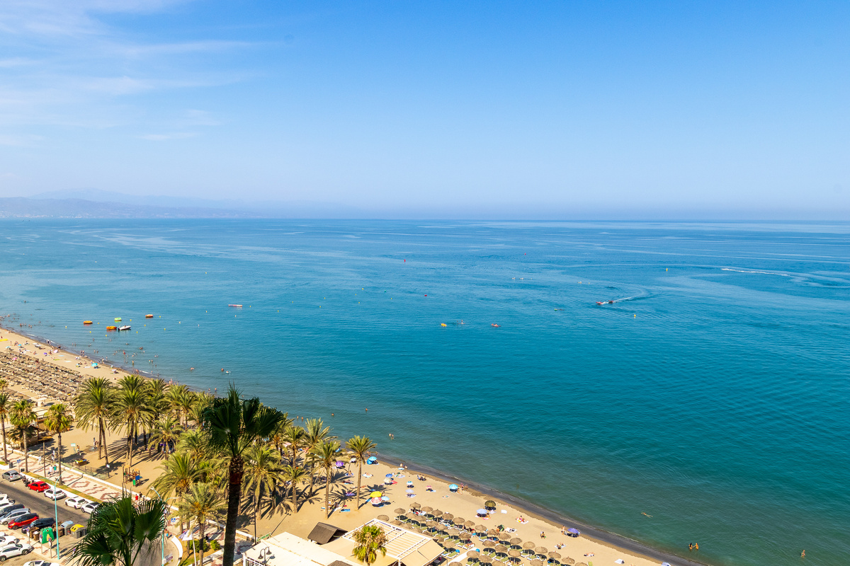 Wide open view of the Mediterranean coastline and beach.