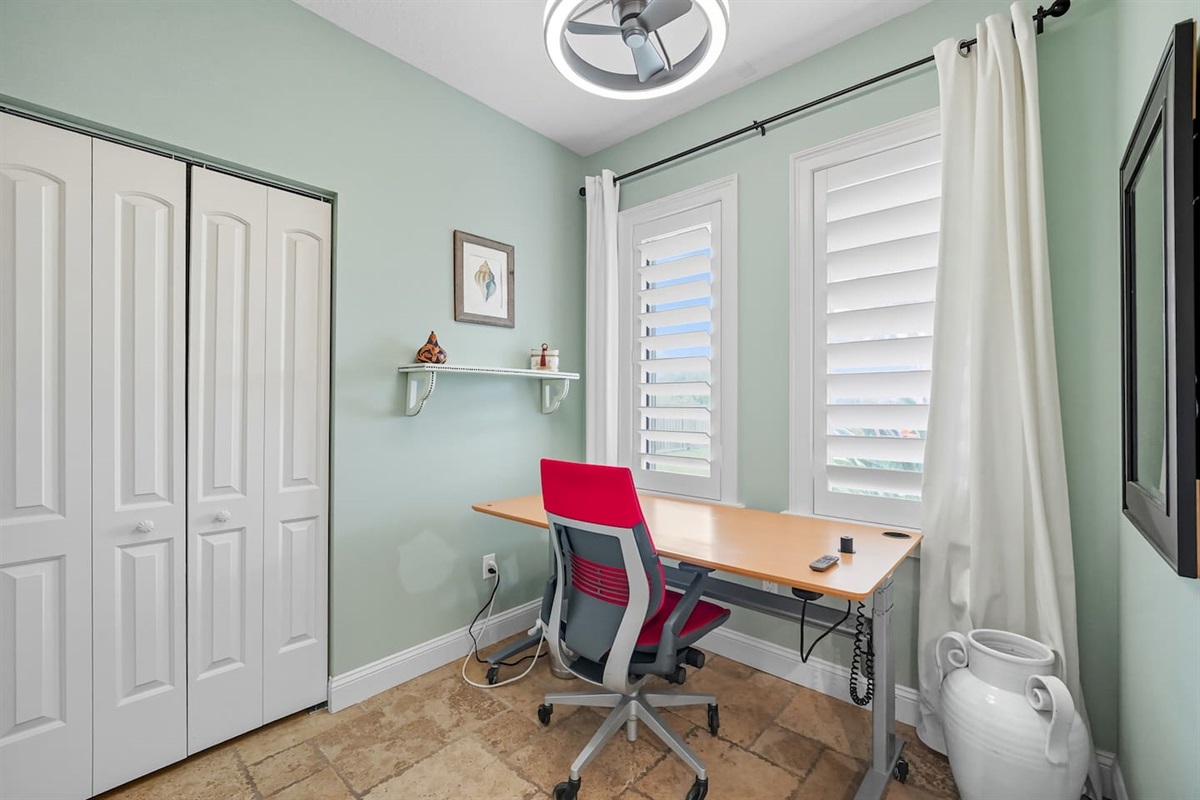 The master bedroom has its very own office workspace with ergonomic office chair.  This space has a personal overhead fan and light, as well as a massive desk overlooking the pool.