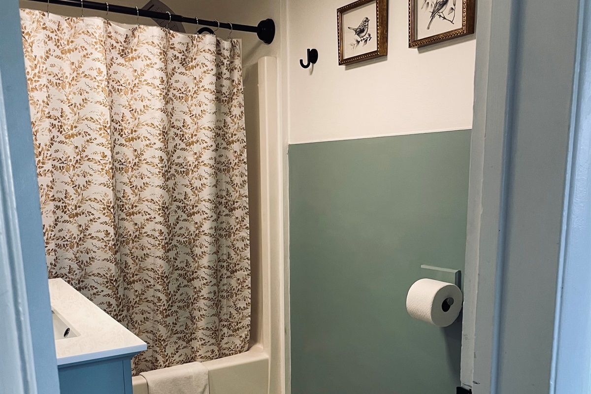 A bright bathroom with a full tub and shower combo, designed for comfort and everyday ease.