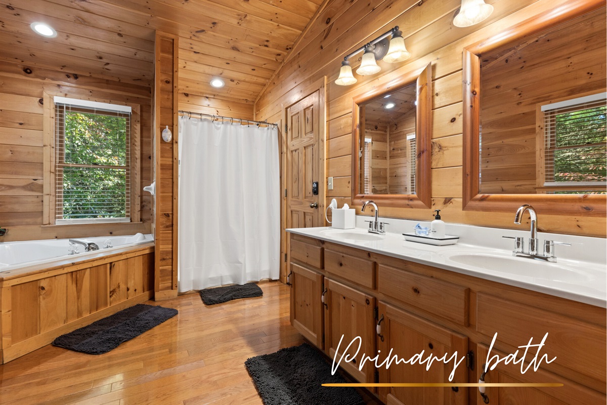 Spa-inspired luxury... a bathtub with forest views, double vanity, and a walk-in shower.