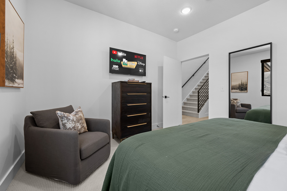 Spacious primary bedroom with Smart TV and cozy seating area.