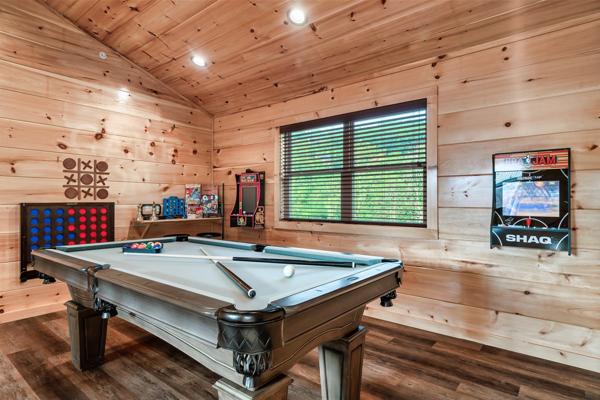 Game room featuring a pool table, smart TV and a selection of arcade and board games.