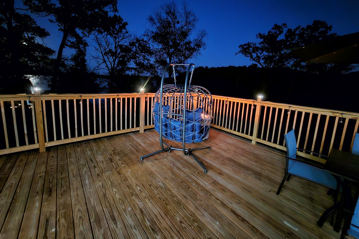 Relax under the stars in the cozy egg chair with soft deck lighting and peaceful lake views