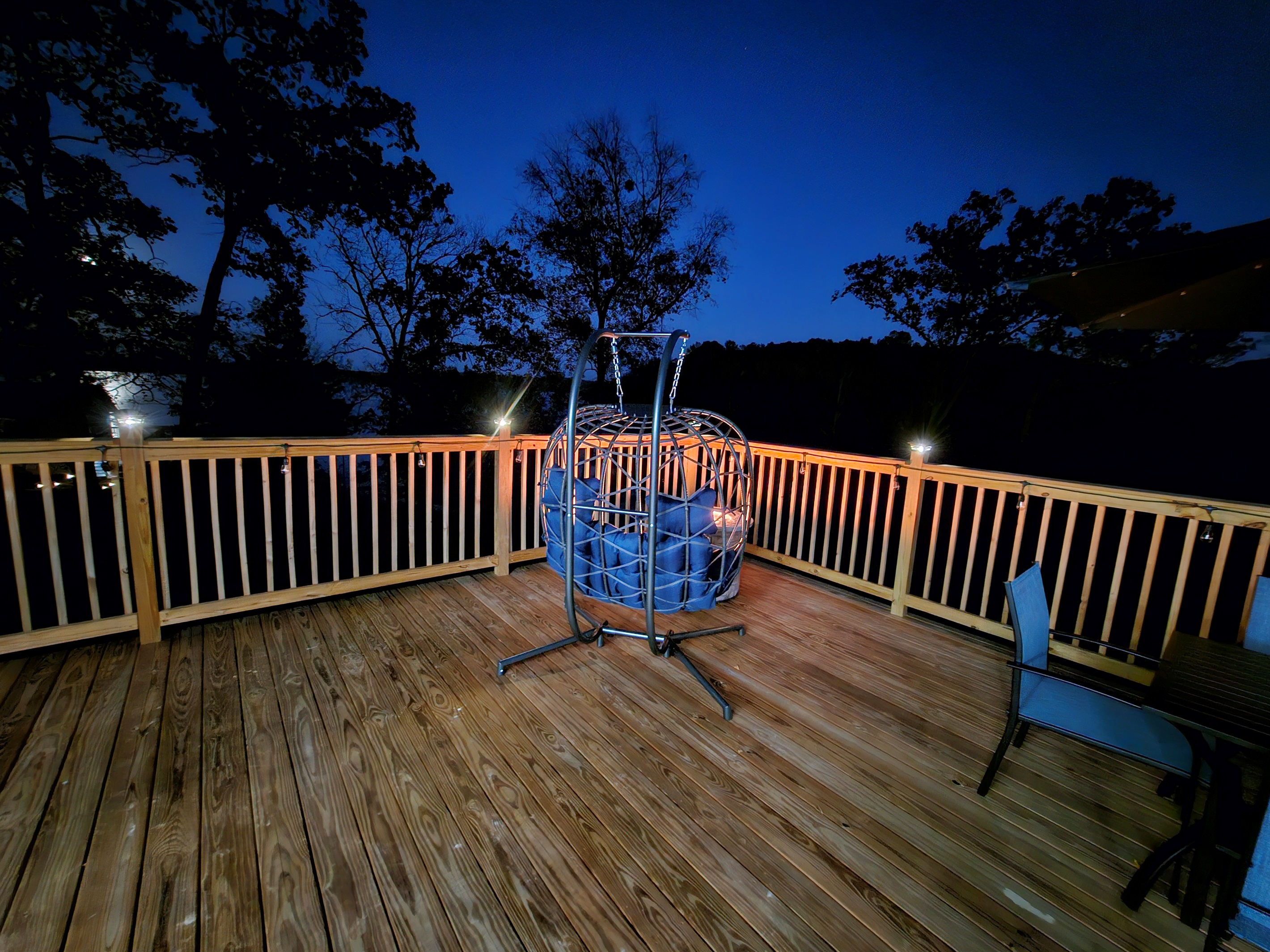 Relax under the stars in the cozy egg chair with soft deck lighting and peaceful lake views