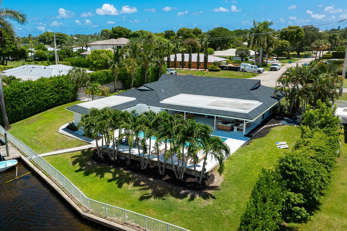 This stunning home sits along a private canal with direct access to Lake Ida, offering a true waterfront retreat. From above, you can see the sparkling pool, lush landscaping, and serene neighborhood that make this property ideal for families and groups.