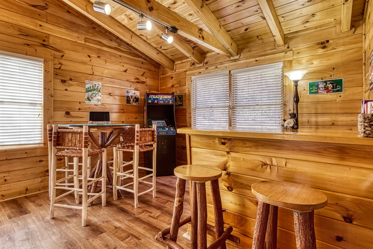 Multicade, poker table, and wet bar in game room upstairs