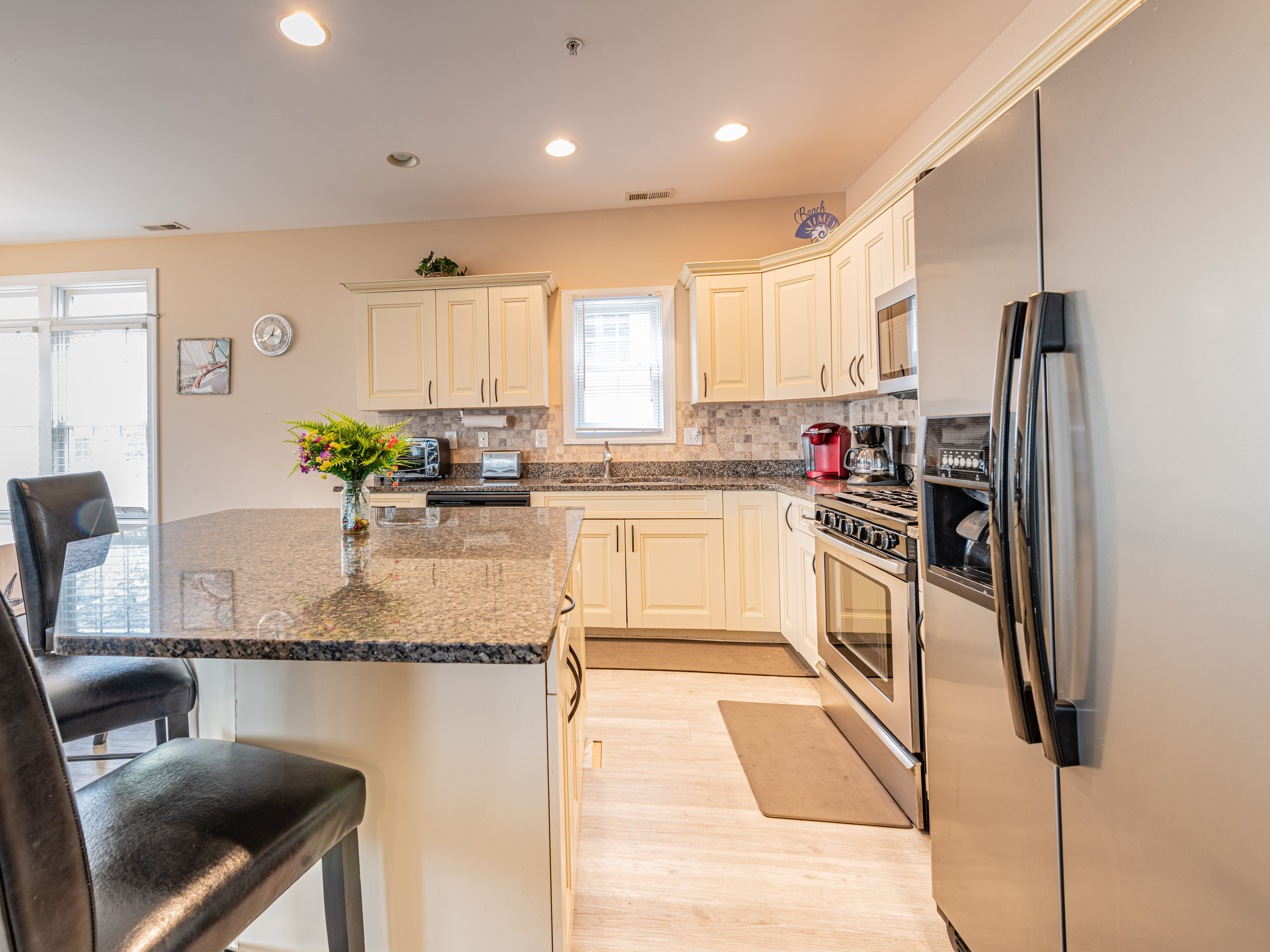 Kitchen Interior View Featuring Island, Granite Countertops, and Refrigerator