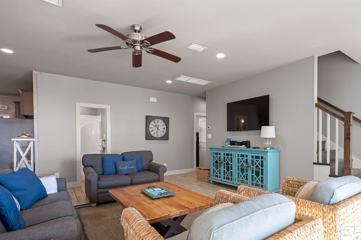 Living room area with plenty of seating and wall mounted Smart TV. Guests must log in to their own streaming services