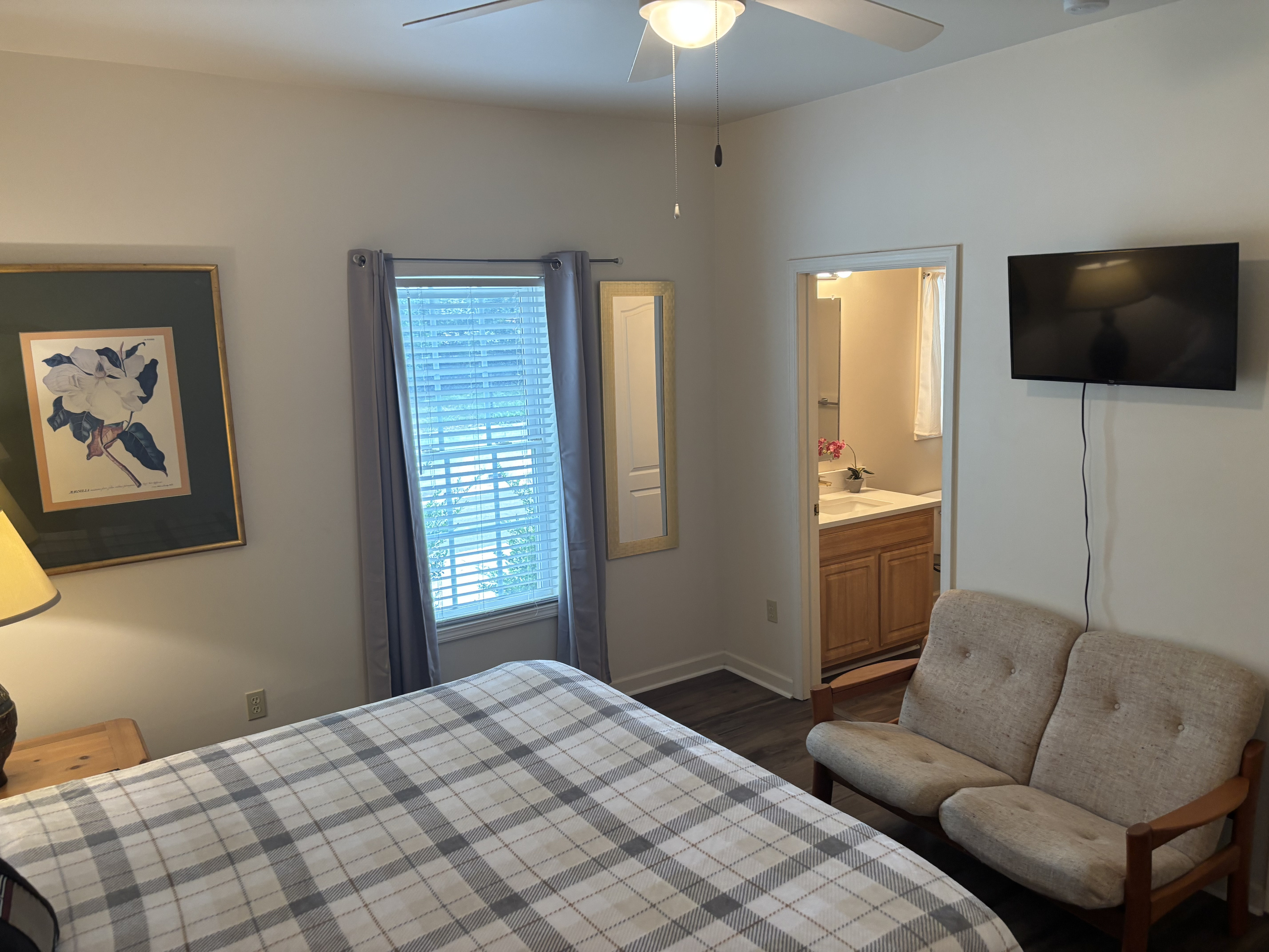 The primary suite includes a king bed, sitting area, walk-in closet and direct access to its private bathroom.