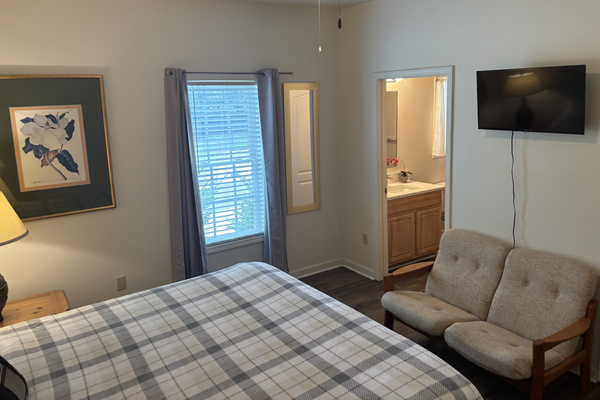 The primary suite includes a king bed, sitting area, walk-in closet and direct access to its private bathroom.
