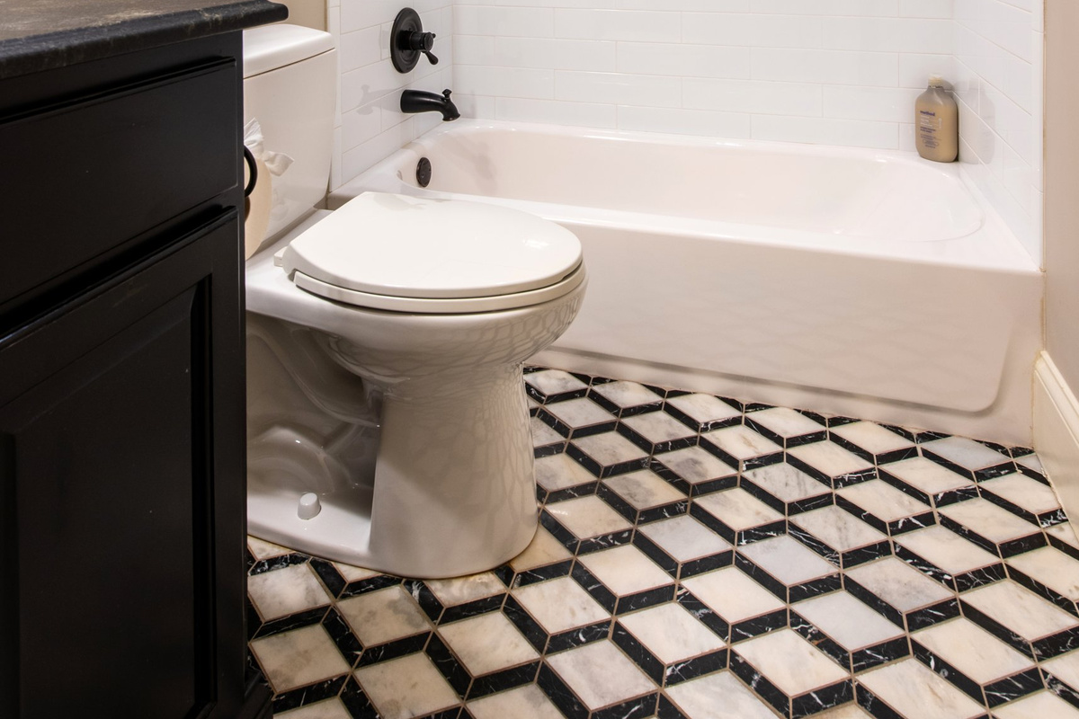 Classic black-and-white tile floor and a tub/shower combo.