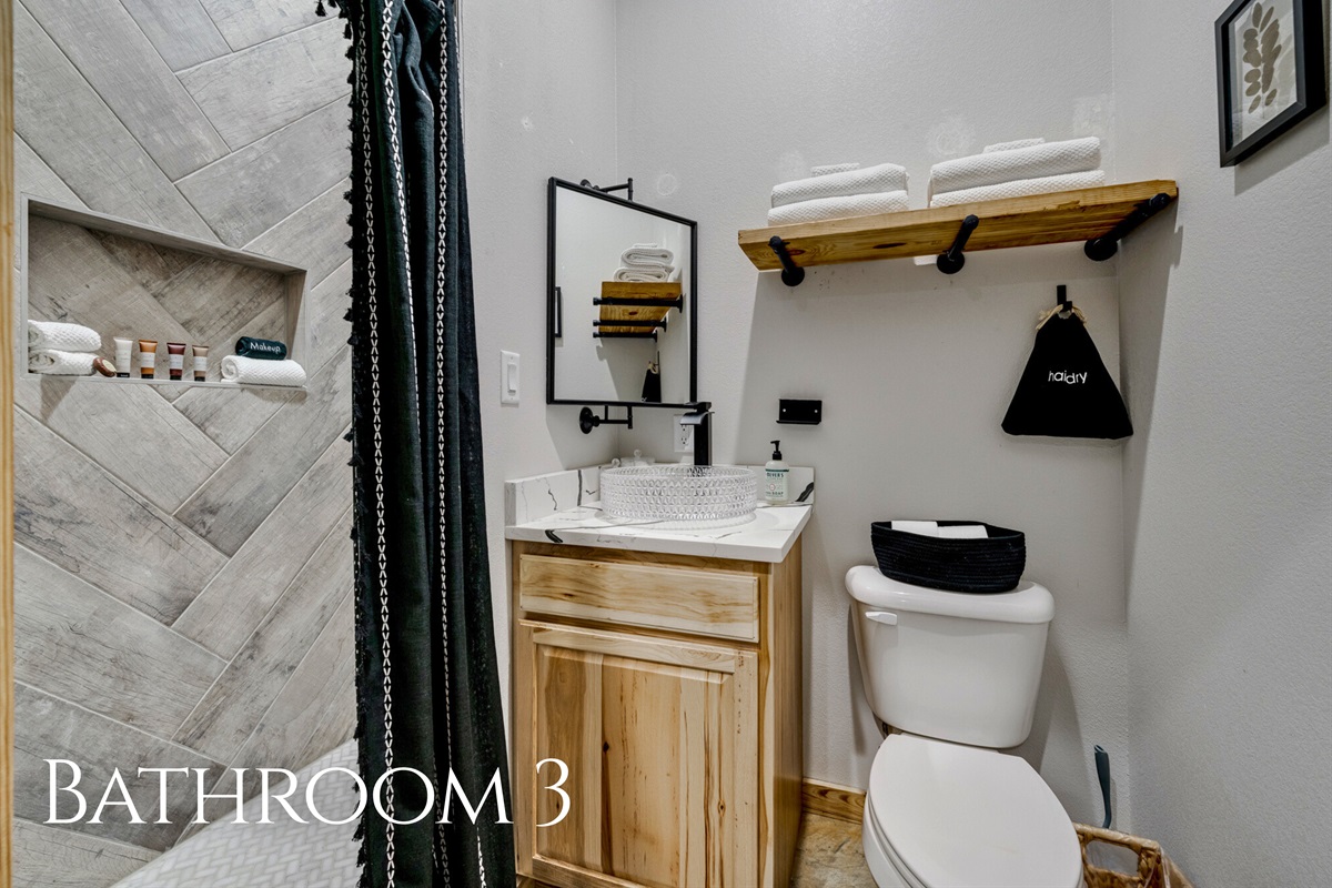 Bathroom 3 offers a sleek shower and practical storage, combining style and convenience in one well-designed space.