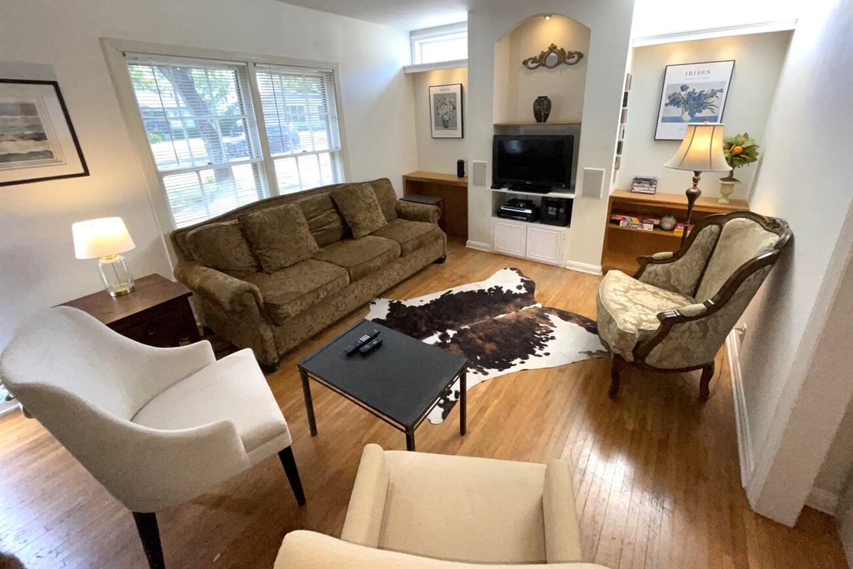 The stylish living room features wood floors, built-in bookshelves and lighting. entertainmet options include LED TV with Roku for streaming, stereo receiver, CD Player, DVD Player.   The sofa is a queen sleeper with gel memory foam mattress.