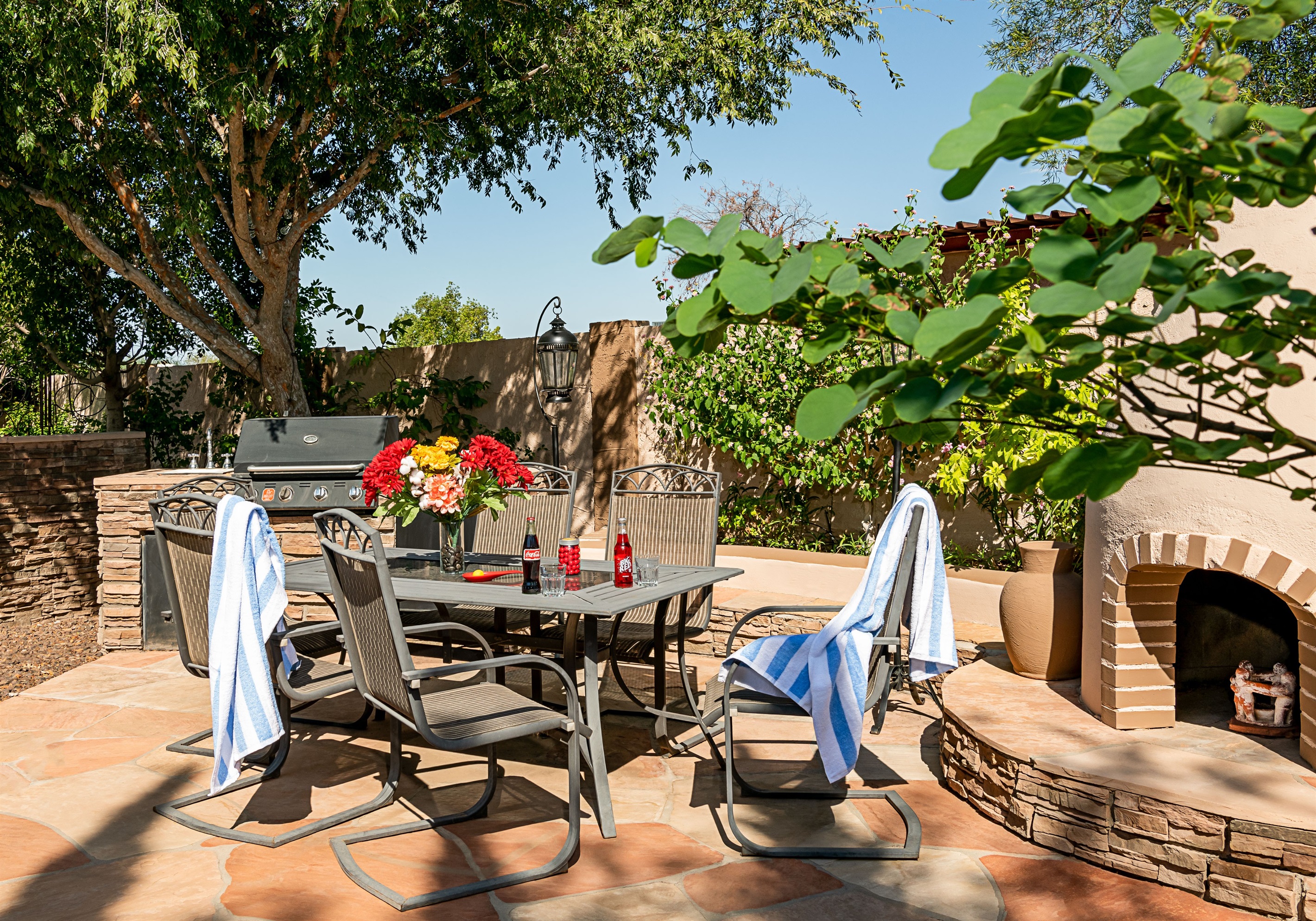 Enjoy alfresco meals in a vibrant garden setting, complete with a grill and shaded table perfect for post-swim gatherings or sunset dinners.