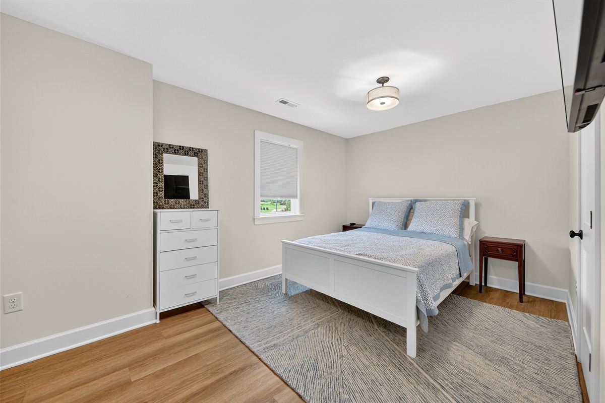 Cozy and inviting guest bedroom featuring a fresh white bedframe and calming neutral tones.