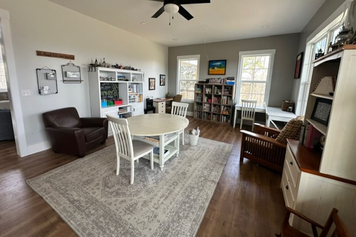 Our library features three work spaces, two comfy chairs for reading, PLENTY of books (we love the classics!), children's art supplies & crafts, as well as a piano and a few guitars. Beautiful views from these windows too. Open to living room/foyer.