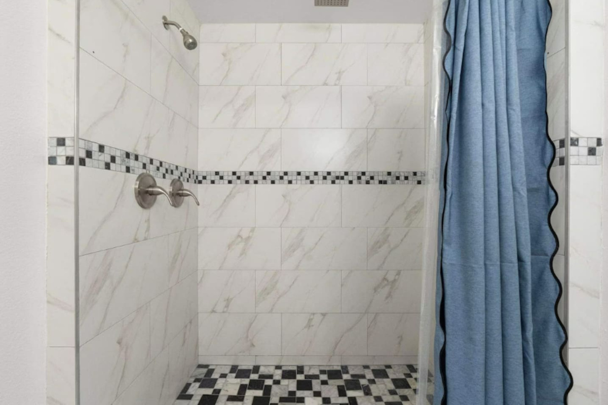 Shower with marble tile and mosaic accents —elegant and spa-inspired for a luxurious experience.