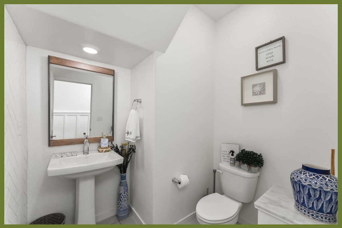 Bathroom with pedestal sink, mirror, fresh towel, and simple guest-ready essentials.