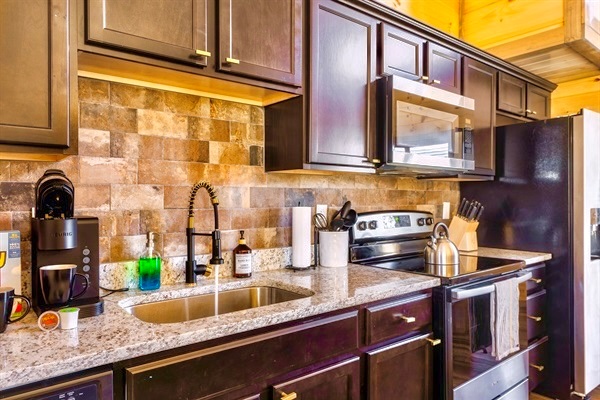 Fully equipped kitchen with top of the line appliances, granite countertops, and a stylish tile backsplash. Perfect for preparing a hearty home-cooked meal or your favorite coffee blend with the Keurig coffee maker.
